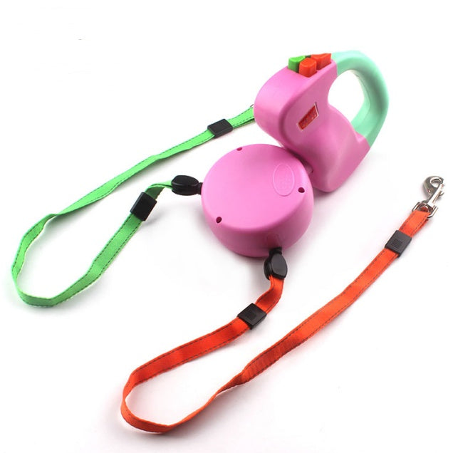 Pink and green retractable dog leashes on a white background