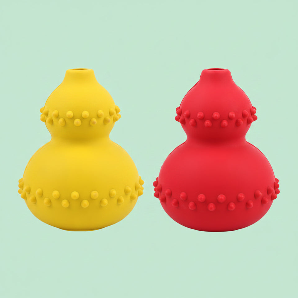 Happy golden retriever rolling interactive treat dispenser toy across carpet.