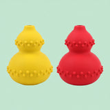 Happy golden retriever rolling interactive treat dispenser toy across carpet.