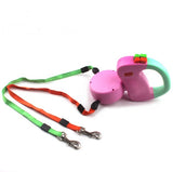 Pink and green retractable dog leash on a white background