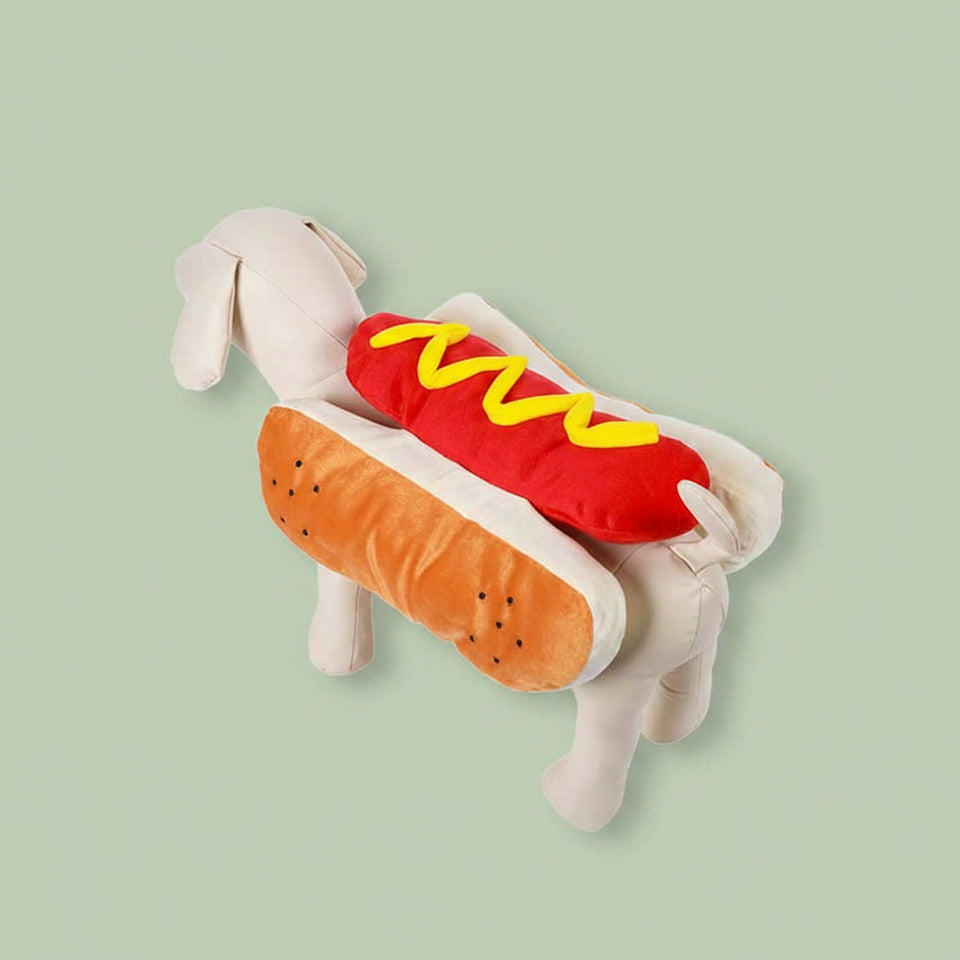 Medium dog sitting comfortably while wearing a funny hot dog pet apparel